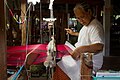 A person weaving silk at a loom, Ban Tha Sawang, Surin Province, Thailand