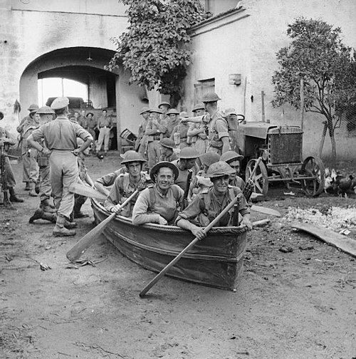 An infantry section from 'B' Company of the 1/6th Battalion, Queen's Royal Regiment try out their collapsible boats in a farmyard in preparation for c