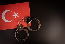 Violation of law, law-breaking concept. Metal handcuffs on flag of Turkey (50860070423).jpg