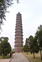 Un mince bâtiment en brique de treize étages avec de petits avant-toits légèrement incurvés entre chaque étage.  Les briques sont de couleur gris foncé, ressemblant à la couleur du fer.