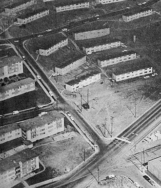 Aerial view of Hunters Point area, facing northeast, where shooting occurred. The intersection where Oakdale Avenue (running east-west) dead-ends into Griffith Street (running north-south) is shown in the center of the photograph, and Navy Road (running east-west) is near the top of the photograph. Temporary "crackerbox" housing for shipyard workers built during World War II can be seen east of Griffith and north of Navy. Aerial view of Hunters Point area where shooting occurred (cropped).jpg