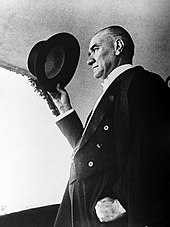 Kemal Ataturk, the founder and the first President of the Turkish Republic Ataturk sapkasiyla selam verirken.jpg