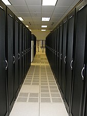 Typical cold aisle configuration with server rack fronts facing each other and cold air distributed through the raised floor. Cabinet Asile.jpg