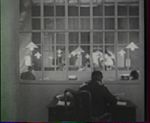 『下宿人』（1927年） 通信社のデスクで後ろ向きに座る。