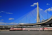 A train at North Station, the inbound terminus of the line Commuter rail train and Bunker Hill Bridge, September 2010.jpg