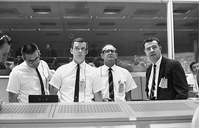 Standing at the flight director's console, viewing the Gemini 10 flight display in the Mission Control Center. Left to right: William C. Schneider, Gl