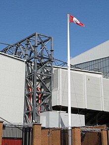 A white flagpole in front of football ground