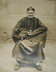 Li Ching-Yuen' nin 256 yıl yaşadığı iddia edilmektedir. Elinde ginseng görülmektedir
