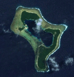 A satellite image of the Pingelap atoll at low-tide. The pale strip in the centre is the airstrip.