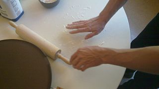 Putting flour on a flat table, in preparation for rolling out the dough.