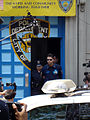 Кроу аз NYPD бо занҷир ҳангоми сайру гашт ба айбдоркунӣ барои ҳодисаи партоби телефон, 6 июни 2005