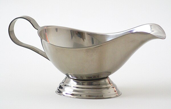 A metal in the form of a gravy boat made from stainless steel, an alloy largely composed of iron, carbon, and chromium