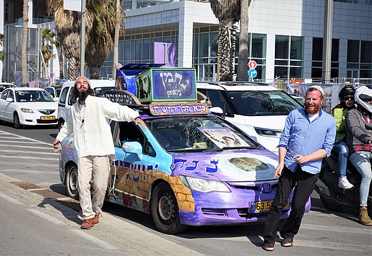 These happy fellows get out of their car to dance in busy Tel Aviv traffic