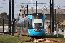 Deux rames Citadis Dualis entrent en gare de Haluchère-Batignolles à Nantes le jour de l'inauguration. Elles franchissent le croisement à niveau avec la ligne du tramway nantais.