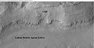 前一桌山背景相机照片的放大版，该图像显示了崖面和舌状岩屑坡的细节，由HiWish计划下高分辨率成像科学设备拍摄于伊斯墨诺斯湖区。