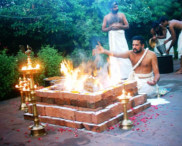 Yajurveda text describes formula and mantras to be uttered during sacrificial fire (yajna) rituals, shown. Offerings are typically ghee (clarified but