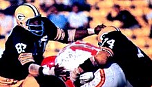 Dawson (center) being tackled by the Green Bay Packers in Super Bowl I, January 1967 1986 Jeno's Pizza - 15 - Willie Davis (Willie Davis crop).jpg