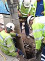 Sucking down a hole being dug to work on gas mains, Deansgate, Manchester. The man on the near right is using a pneumatic drill.