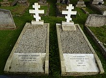 Two white marble gravestones surmounted by Orthodox crosses