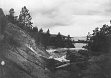 old landscape photography with rock, creek and a lake in the background