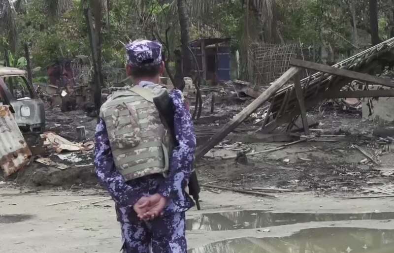 File:BGP officer near a burnt down house in Rakhine State.jpg