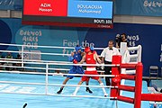 Deutsch: Boxen bei den Olympischen Jugendspielen 2018 Tag 12, 18. Oktober 2018 - Kampf um Bronze im Leichten Weltergewicht Jungen – Hassan Azim (Großbritannien, rot) schlägt Mohammed Boulaouja (Marokko, blau) RSC; Ringrichter ist Wulfren Olivares Peréz (Kolumbien). English: Boxing at the 2018 Summer Youth Olympics on 18 October 2018 – Bronze Medail Match Light Welterweight Boys - Hassan Azim (Great Britain, red) beats Mohammed Boulaouja (Morocco, blue) RSC; Referee is Wulfren Olivares Peréz (Columbia). Español: Boxeo en los Juegos Olímpicos Juveniles de Verano de 2018 en 18 de octubre de 2018 - Medalla de bronce de los hombres ligeros de peso welter: Hassan Azim (Gran Bretaña, rojo) vence a Mohammed Boulaouja (Marruecos, azul) RSC; El árbitro es Wulfren Olivares Peréz (Colombia).