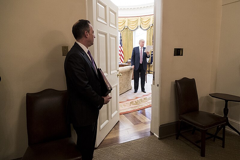 File:Chief of Staff Reince Priebus looks into the Oval Office as President Donald Trump reads over his notes, March 2017.jpg