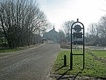 View south up Station Brae over Dreghorn Bridge across the Annick Water to the Parish Church, with NCR73 sign at the site of the station. Dreghorn Station Brae.jpg