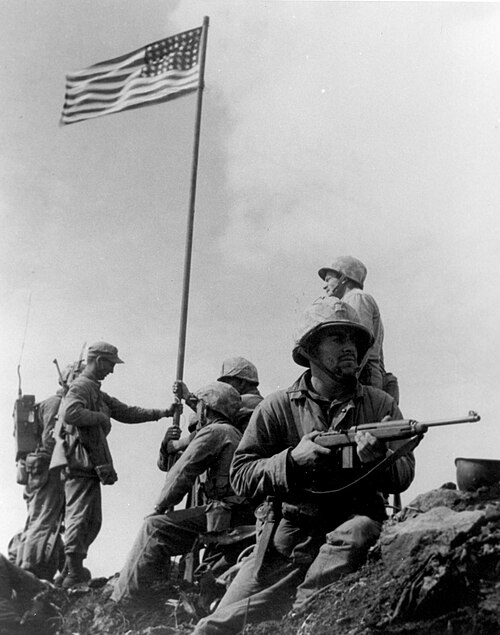 Marine Staff Sergeant Louis Lowery's most widely circulated picture of the first American flag on Mount Suribachi (after the flag was raised): Left to