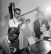 Davis on piano with Howard McGhee (trumpet), Joe Albany (pianist, standing) and Brick Fleagle (guitarist, smoking), September 1947 Howard McGhee, Brick Fleagle and Miles Davis, ca September 1947 (Gottlieb).jpg