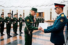 Ground Forces soldiers taking the military oath in the "office" uniform introduced in 2013. Note the officer on the right in the obsolete open-collar tunic which is currently being phased out. MilitaryOath2018-04.jpg