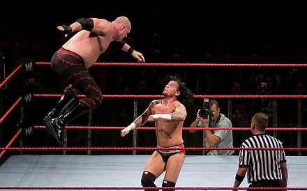 Kane performing a flying clothesline on CM Punk