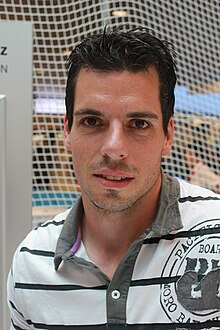 Retrato de un hombre de frente, vestido con una camiseta de polo.  Fotocromía