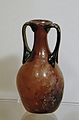 Two-handled amphora-shaped balsamarium (perfume flask). Purple glass, 1st-2nd centuries CE.