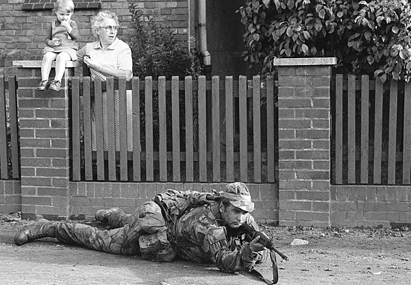 A German woman and child watching a British Army soldier in their village during Reforger 80