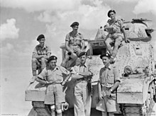 Lieutenant Colonel Sir Ranulph Twisleton-Wykeham-Fiennes, OC Royal Scots Greys in 1942, posing with the crew of his Grant command tank in September 1942. This photograph was taken just after the Scots Greys' first engagement as an armoured unit at the Battle of Alam el Halfa RSG CO tank in Desert (WWII).jpg