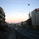 La rue Lauttasaarentie bordée d'immeubles d'habitation des années 1960 à 1980, avec en arrière-plan le pont de Lauttasaari.