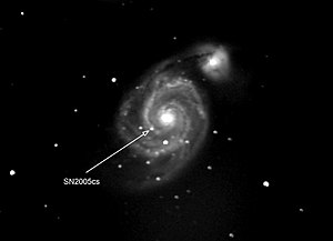 Photograph of supernova in another galaxy. The supernova is pointed by the arrow. The other bright spots are stars of our own galaxy that happen to be in front of the other galaxy