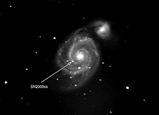 Photograph of supernova in another galaxy. The supernova is pointed by the arrow. The other bright spots are stars of our own galaxy that happen to be in front of the other galaxy