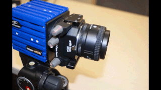 A scientific camera with a Scheimpflug adaptor mounted between the lens and the camera, showing in stop-motion the potential movements the adaptor provides in the two axes (tilt and swing).