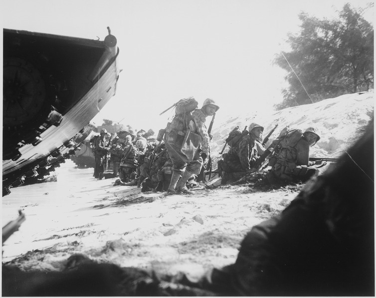 File:The first wave of Marines to hit the Saipan beach in the Marianas invasion take cover behind a sand dune, while... - NARA - 532527.tif