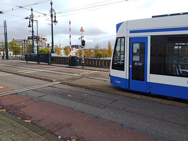 File:Tram is moving on the bridge Nieuwe Amstelbrug, over the Amstel river; free photo Amsterdam, Fons Heijnsbroek, 08-11-2021.jpg