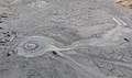 Una bombolla de gas que esclata per la boca d’un volcà de fang