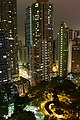 Le parc de nuit aux pieds de grands immeubles.