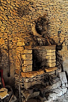 Workshop with fireplace in dry stone cottage, France.jpg