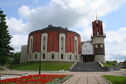 Farvefoto af en cirkulær bygning med et klokketårn.