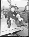 (Man sitting on deck putting boots on) (Frank Hurley) (19849744203).jpg