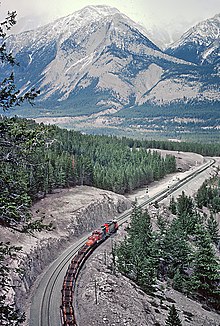 A CN freight train led by a diesel locomotive at the crossovers at English which is east of Jasper, Alberta 8 Canadian National Freights in Alberta From Roger Puta (31468180173).jpg