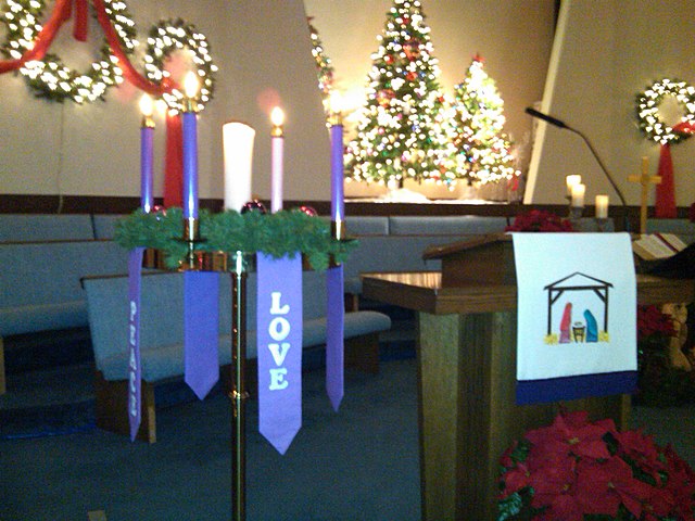 A white coloured parament hangs from the pulpit, indicating that the current liturgical season is Christmastide. The fact that the Christ Candle in th