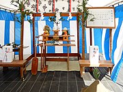 神道における地鎮祭の祭壇。地面にコモを敷き、木で棚を組み、周囲の四方に榊を立てて注連縄で結び、紙垂を垂らす。